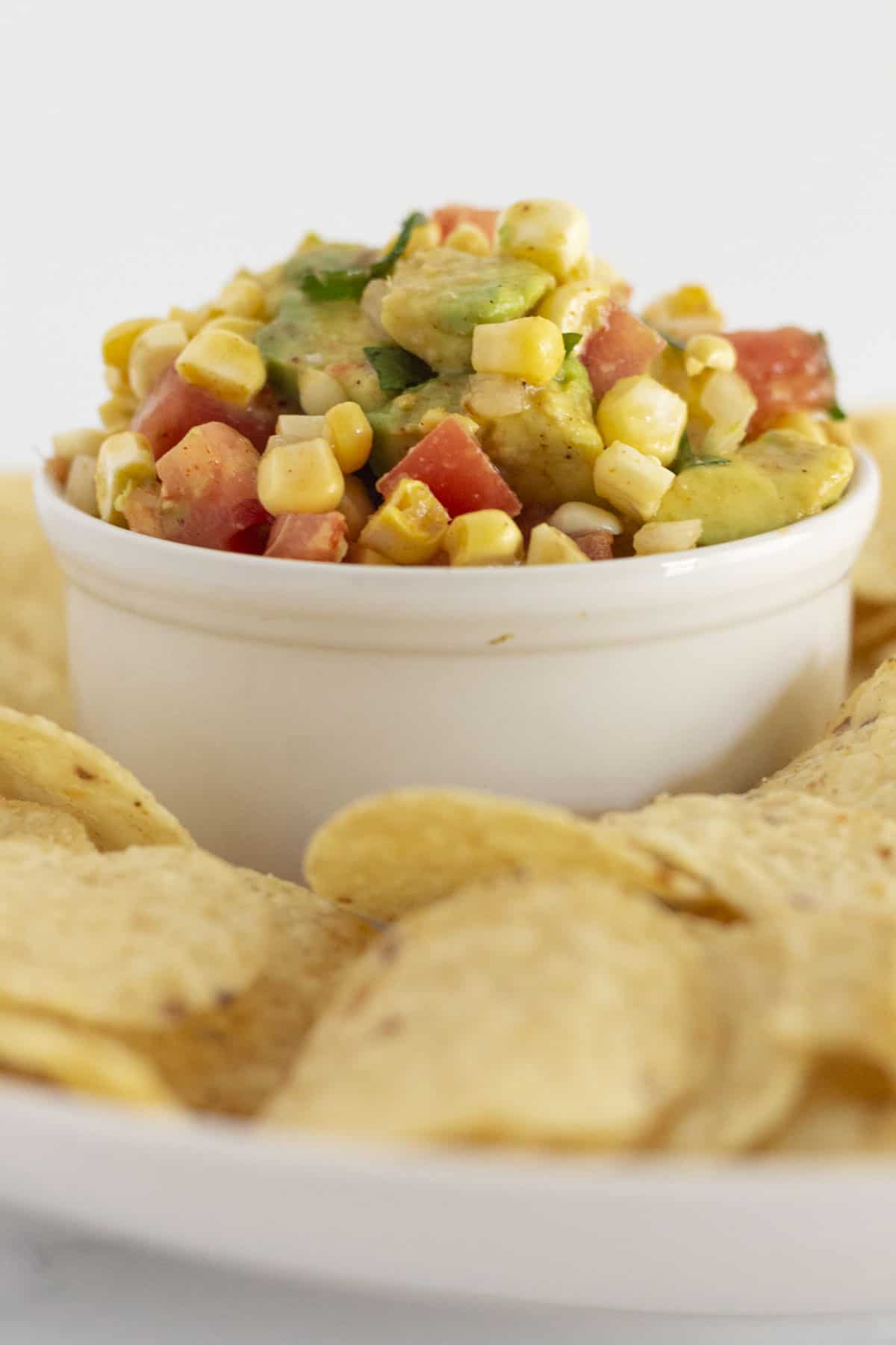 Corn and avocado salsa served with corn chips.