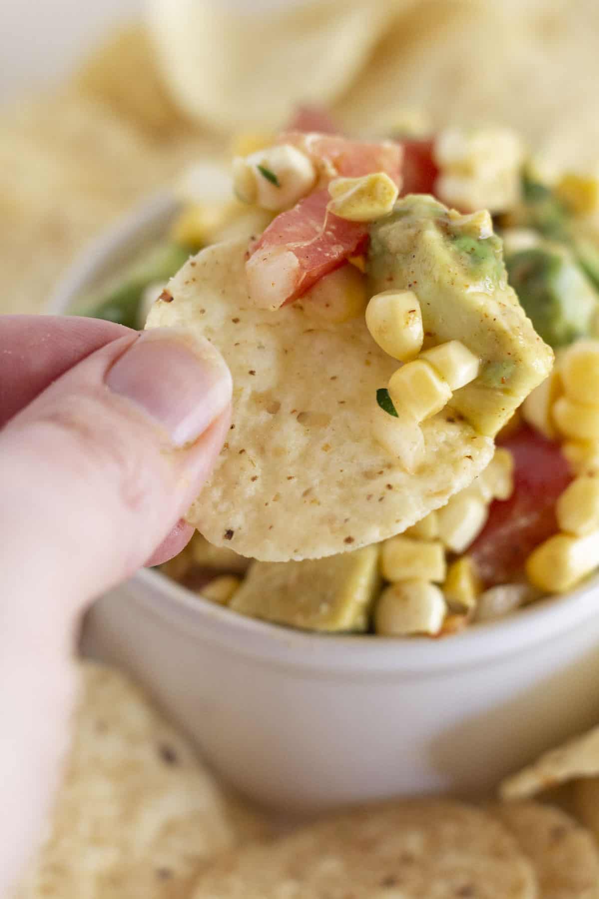Dipping corn chips in the corn and avocado salsa.