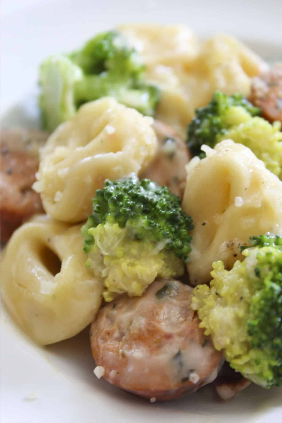Sausage and Tortellini Skillet with broccoli served on a white plate.