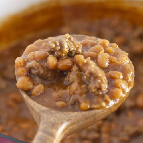 Serving a spoon of baked beans with ground beef.