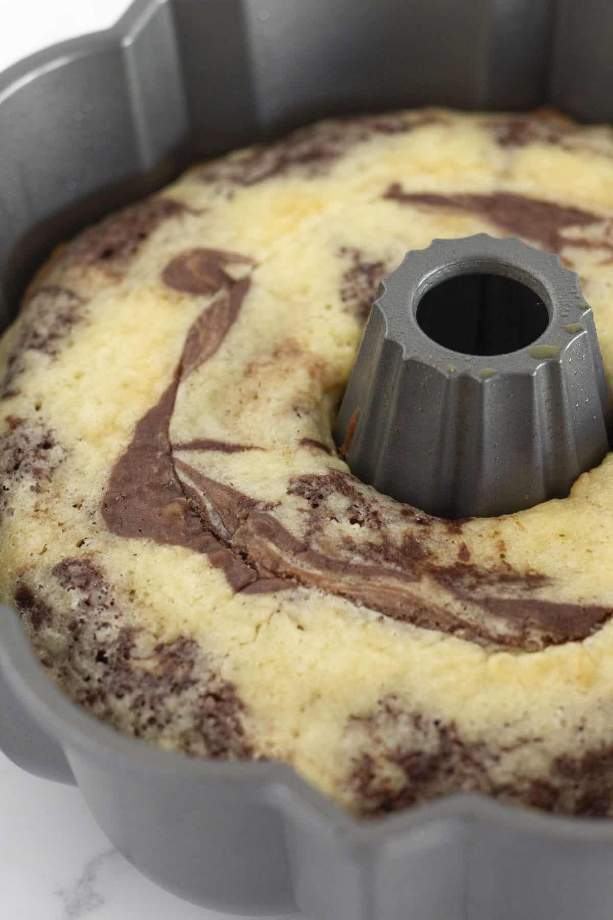 A marble cake in a bundt pan cooling for 10 minutes.