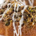 A close up of pistachio bundt cake with vanilla glaze.
