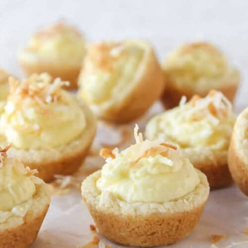 Eight coconut cream pie cookies with toasted coconut on top.