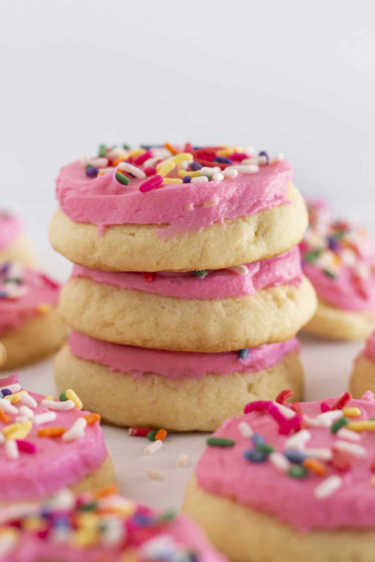 Homemade lofthouse sugar cookies with rainbow sprinkles stacked on each other.