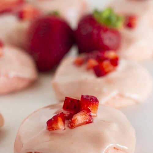 Strawberry cake mix cookies on a white tray with fresh strawberries.
