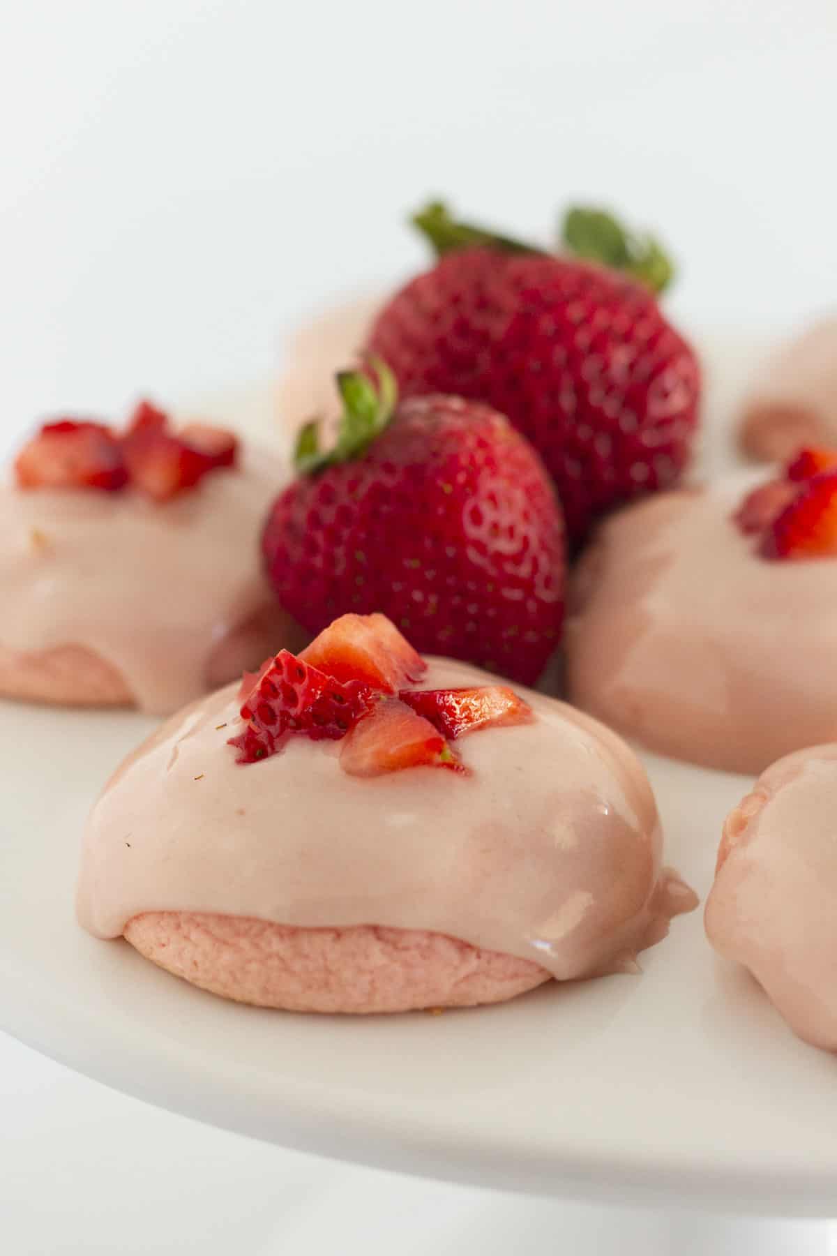 Strawberry cake cookies on a white cake plate.