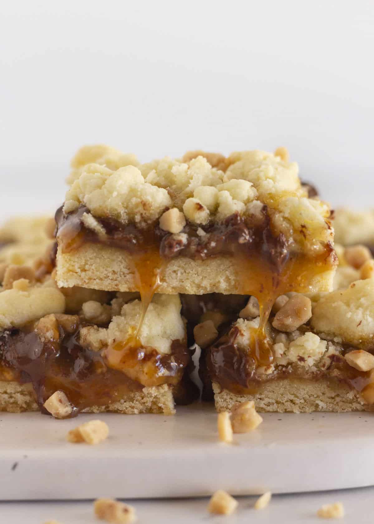 Toffee cookie bars stacked on each other with caramel and chocolate chips.