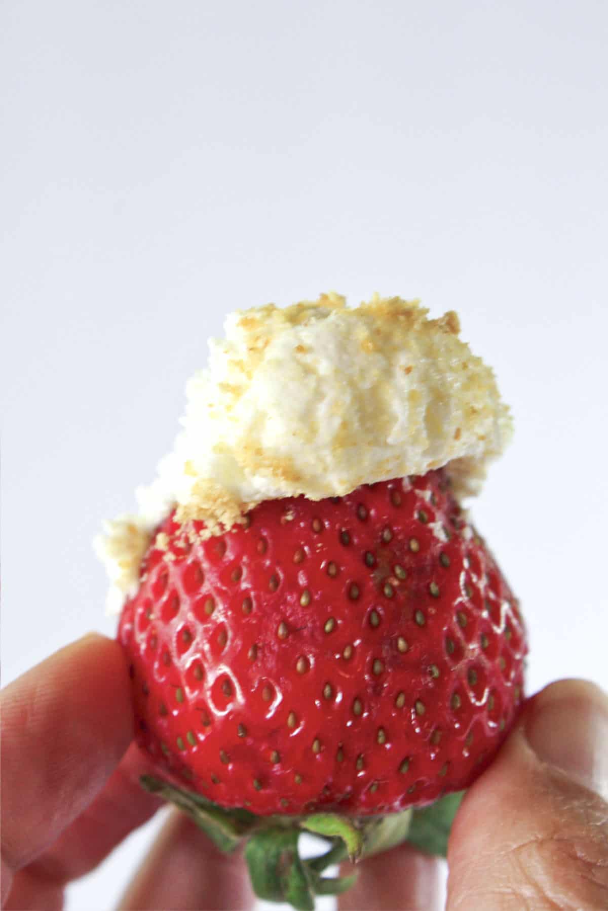 Cheesecake fruit dip on a fresh strawberry.