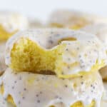 Lemon cake donuts with a bite taken out of the top one.