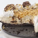 Looking inside a Snickers cheesecake that a has a few slices missing.