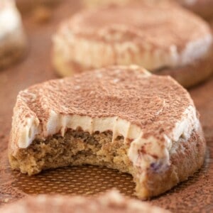 Tiramisu cookies on a cookie sheet with a bite taken out of one.