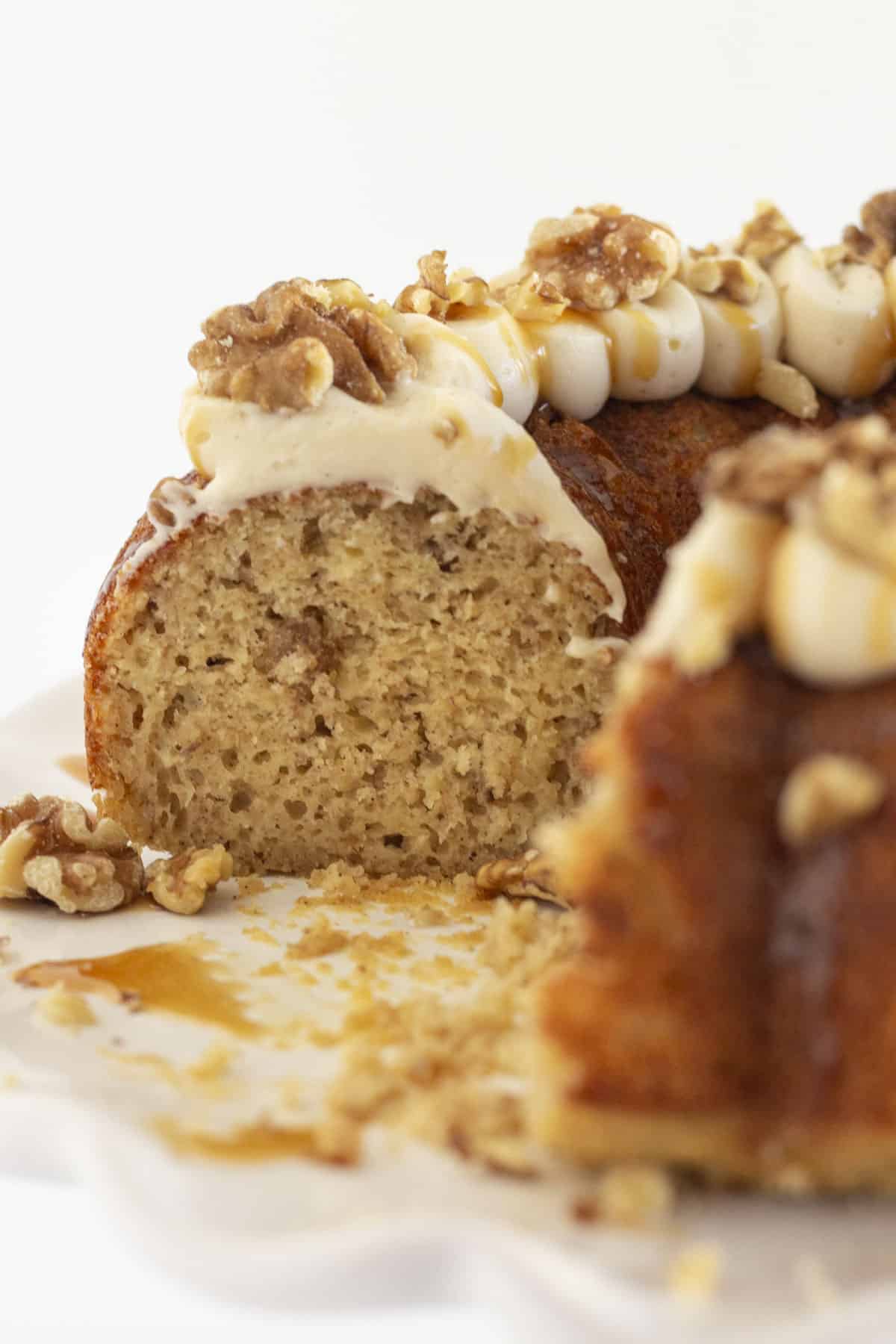 Serving slices of banana walnut bundt cake with caramel cream cheese frosting.