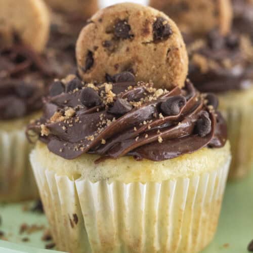 Chocolate chip cookie cupcakes on a green cake plate.