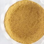 A homemade graham cracker crust in a white pie plate.