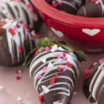 Chocolate dipped Valentine strawberries on a pink plate for serving.