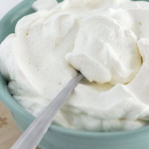 Fresh made whipped cream in a bowl with a spoon for serving.