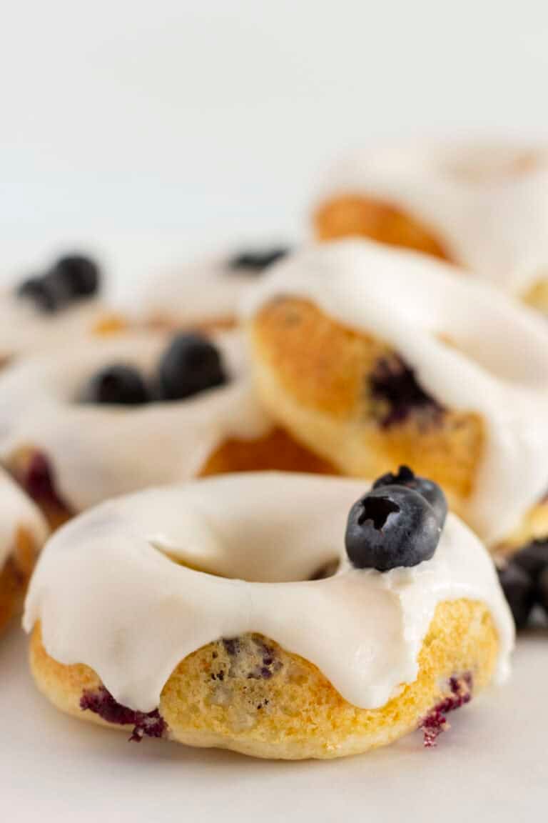 Blueberry Cake Donuts ready to serve with fresh blueberries and glaze.