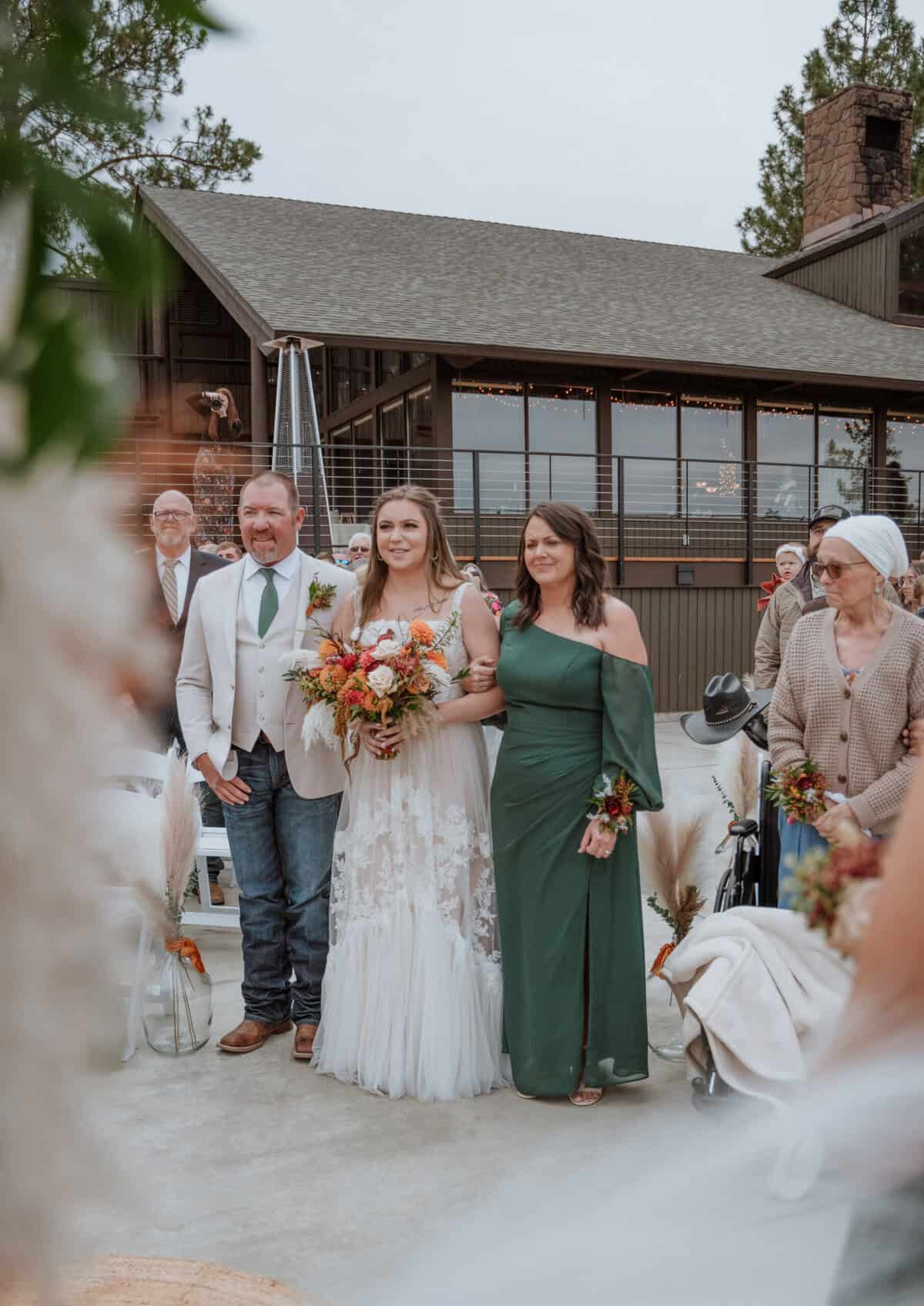 Father and mother walking the bride down the aisle.