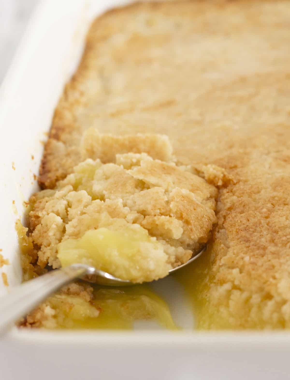 Getting a spoonful of lemon dump cake to serve.