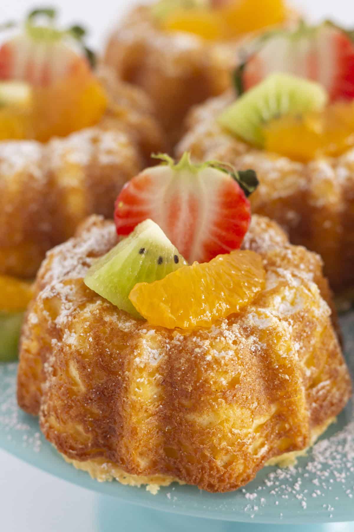 Mini pound cakes with fresh fruit on a cake plate.