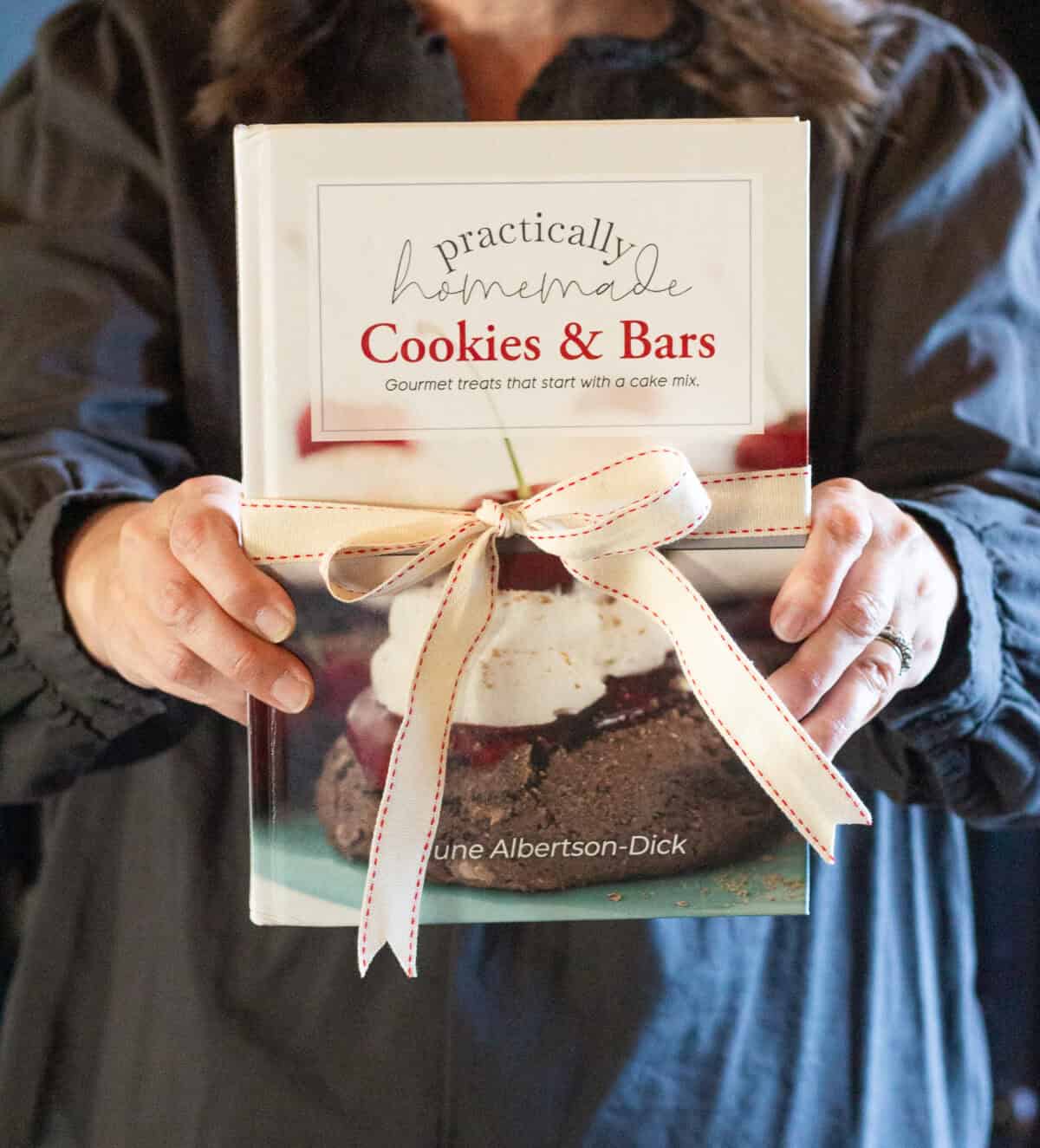 June holding her Practically Homemade Cookies & Bars cookbook.