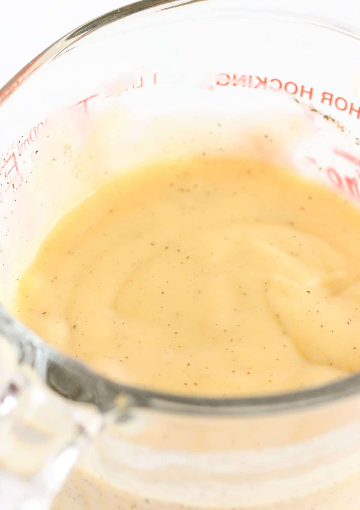 A bowl with cream chicken soup, milk and spices.