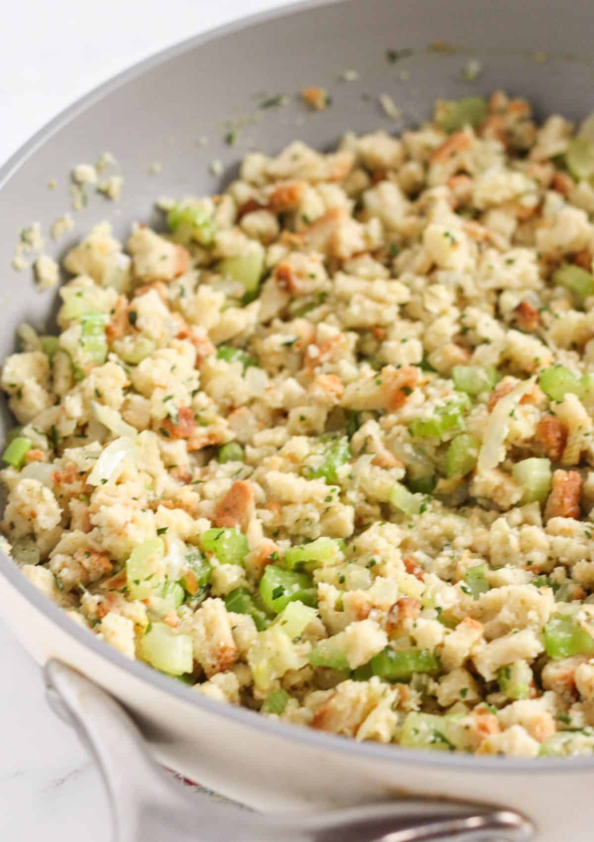 Adding the stuffing mix and chicken stock to the vegetables.