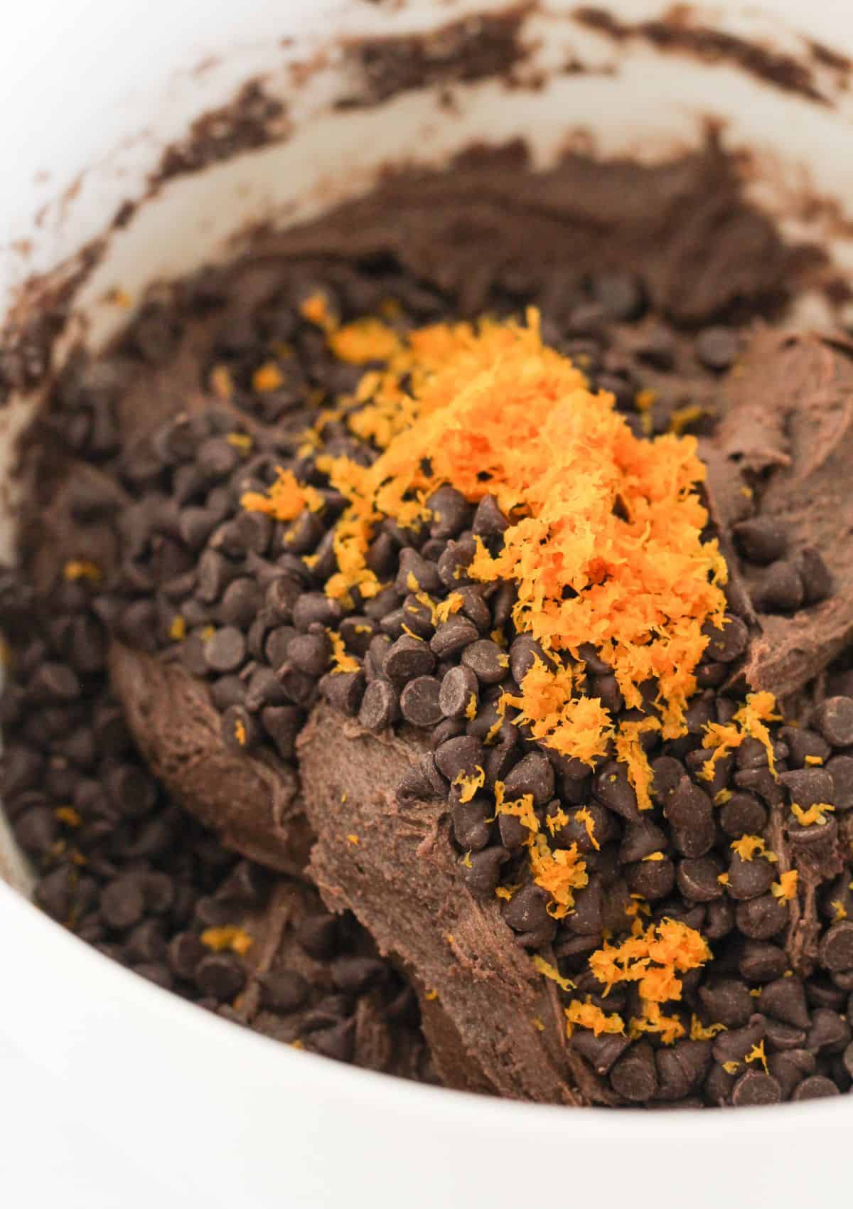 Adding the orange zest and chocolate chips to cookie dough.