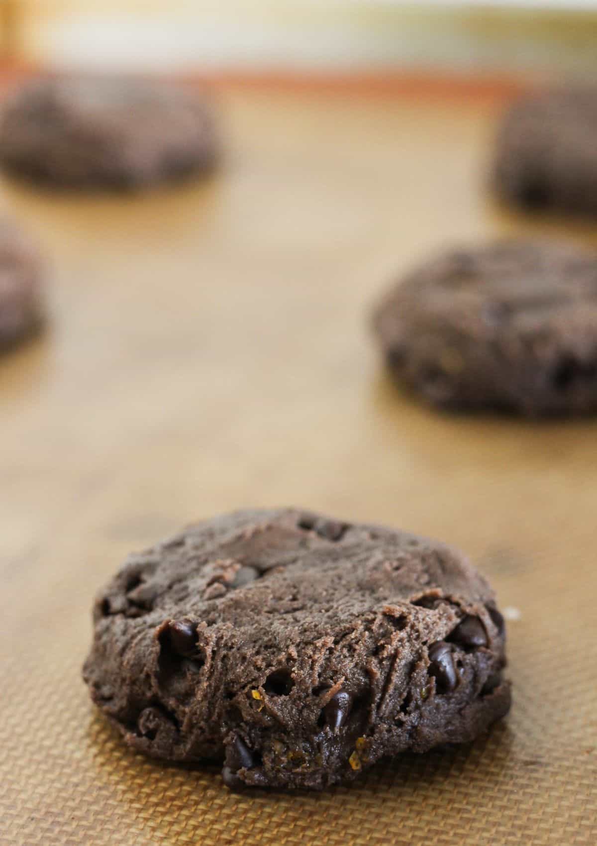 Chocolate orange cookie dough on a baking sheet.