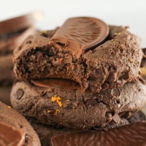 Stacks of chocolate orange cookies with a bite taken from one.