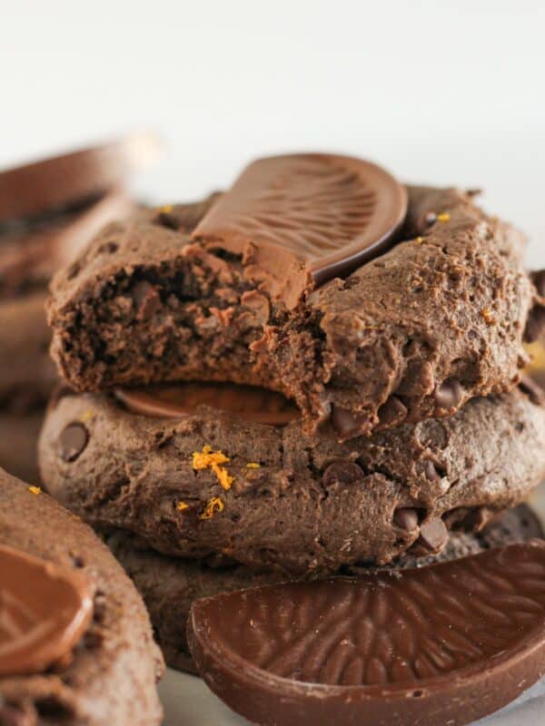 Stacks of chocolate orange cookies with a bite taken from one.
