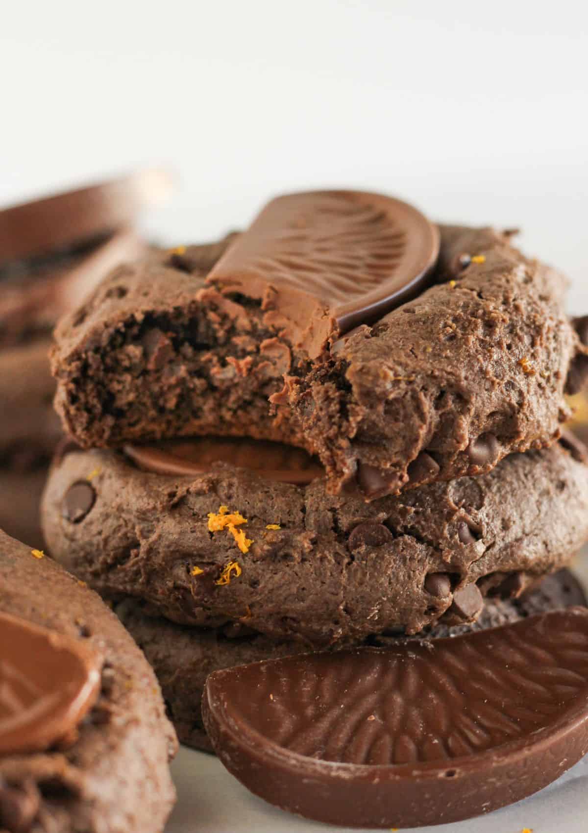 Stacks of chocolate orange cookies with a bite taken from one.