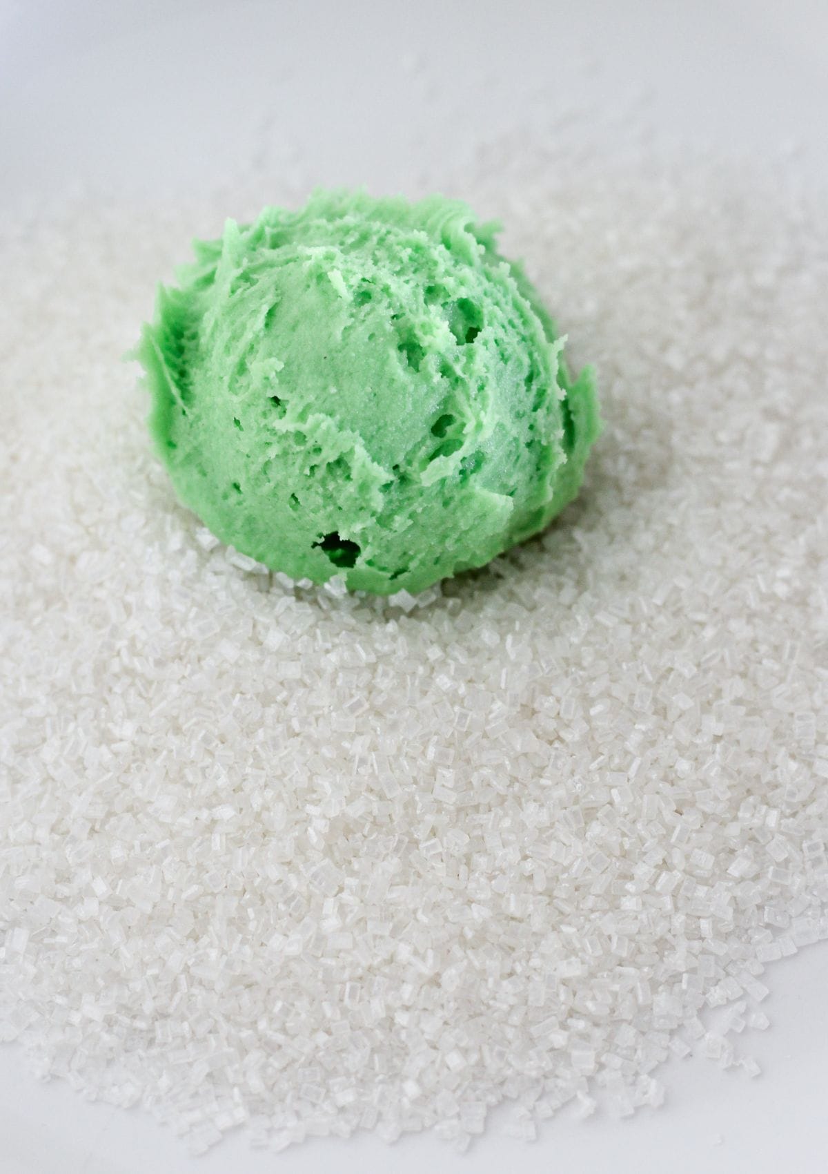 Rolling the green cookie dough in sugar.