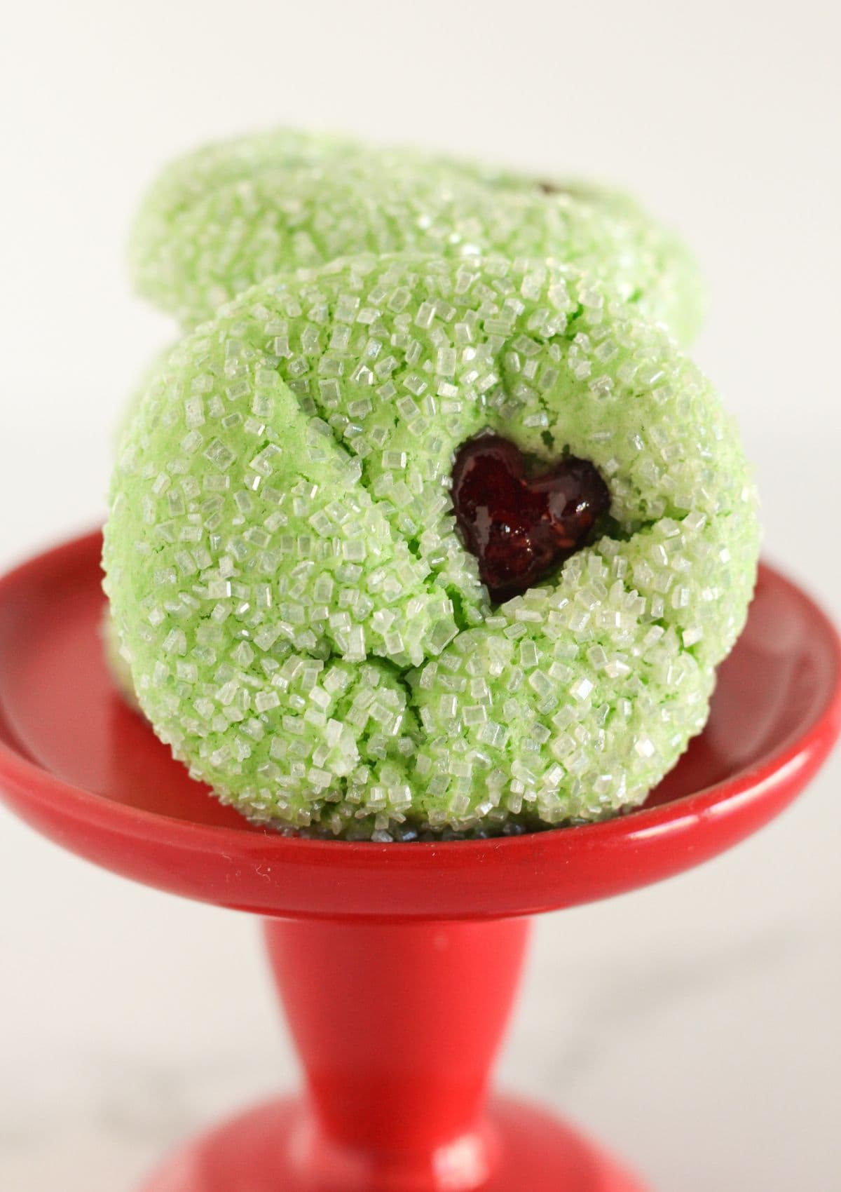 4 Grinch cookies on a small red tray.