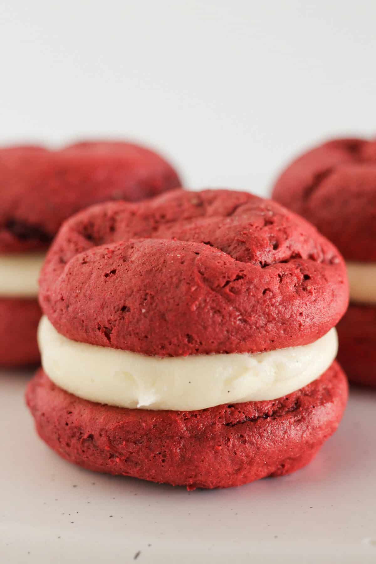 Finished red velvet whoopie pies with cream cheese frosting.