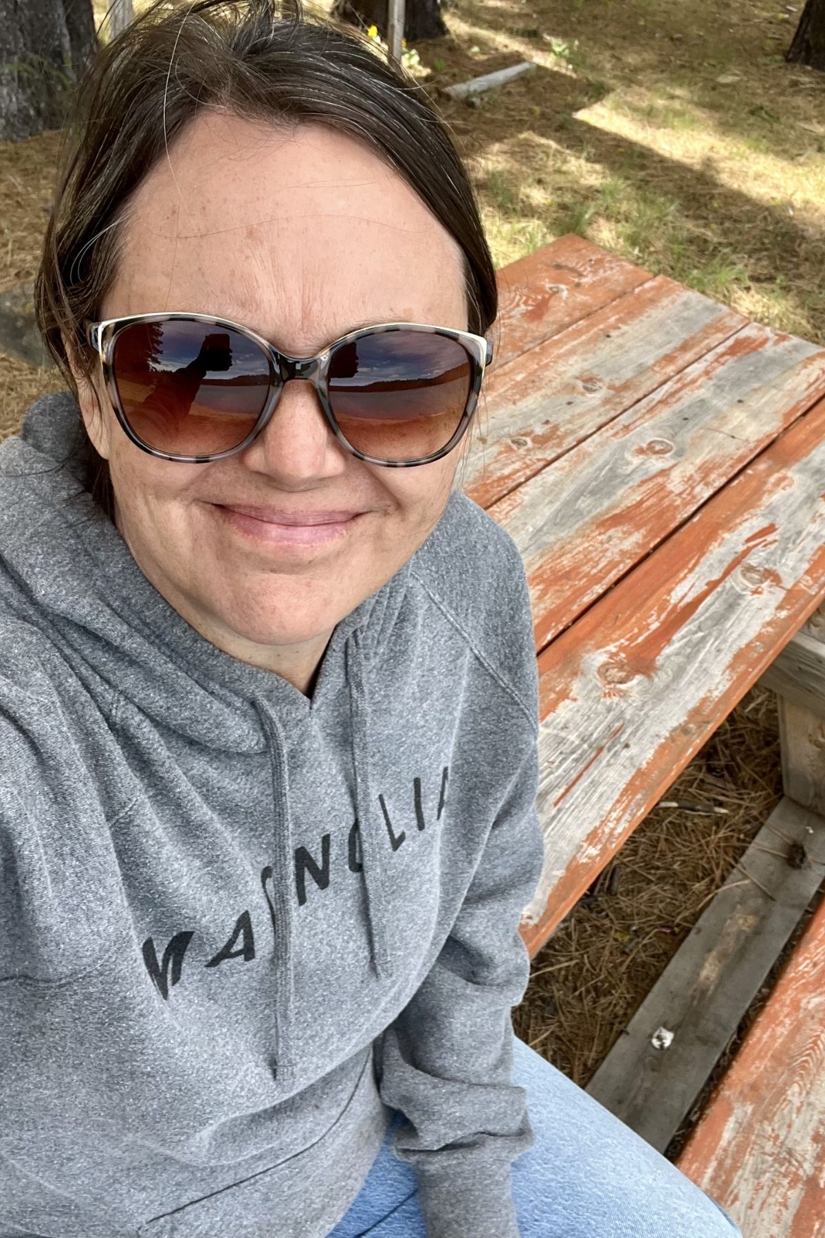 Sitting on a picnic table at a reservoir.
