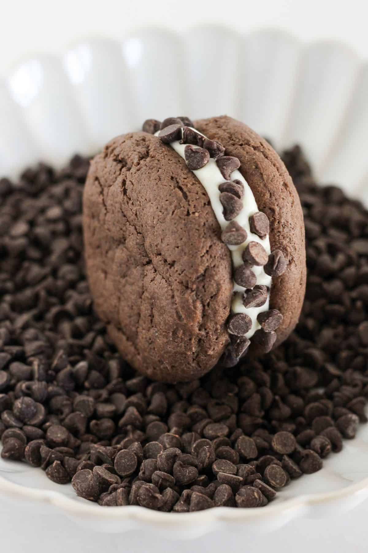 Rolling a sandwich cookie in mini chocolate chips.
