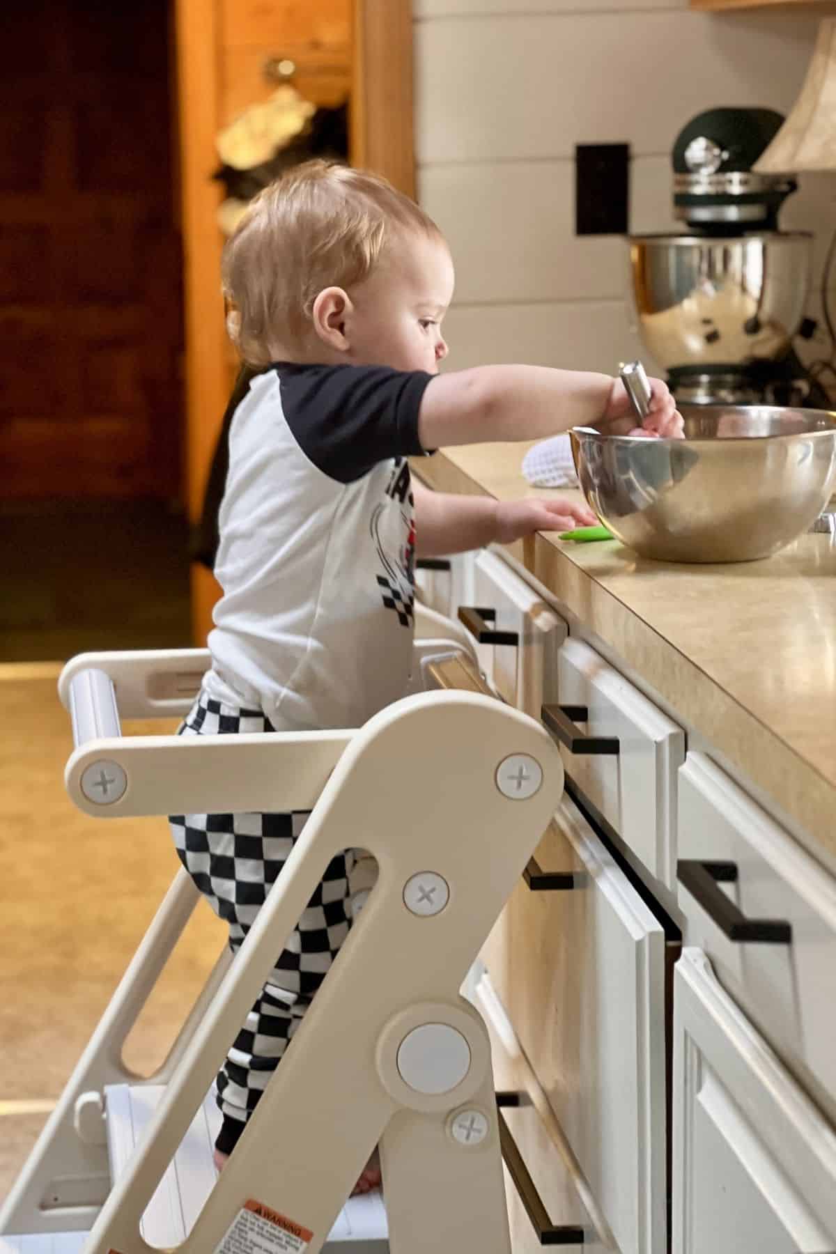My grandson at the counter stirring ingredients.
