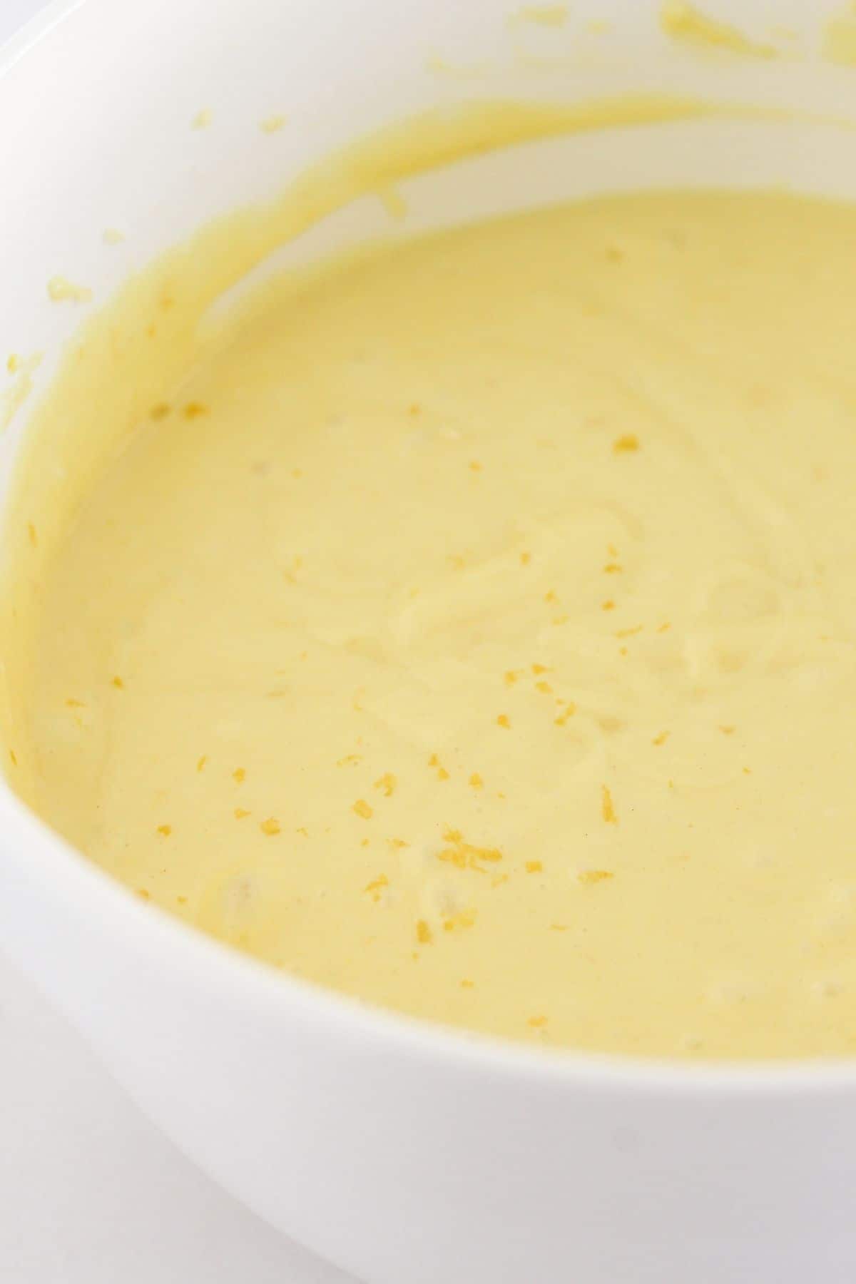 Adding fresh lemon zest to a lemon cake.