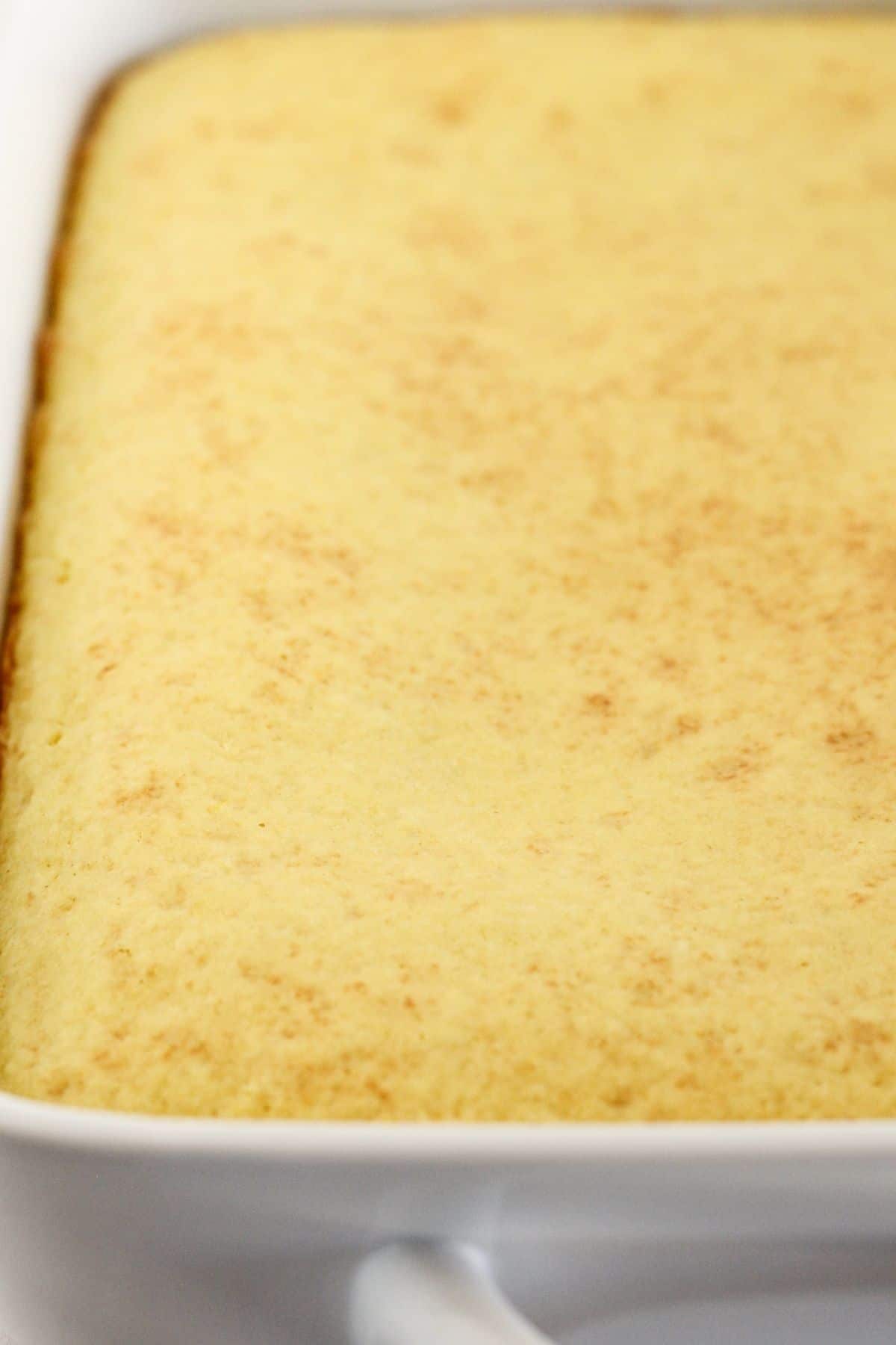 A baked lemon cake in a 9x13 baking pan.