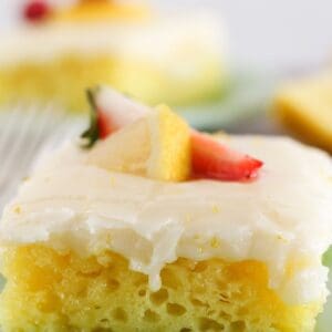 Lemon sheet cake squares on green plates.
