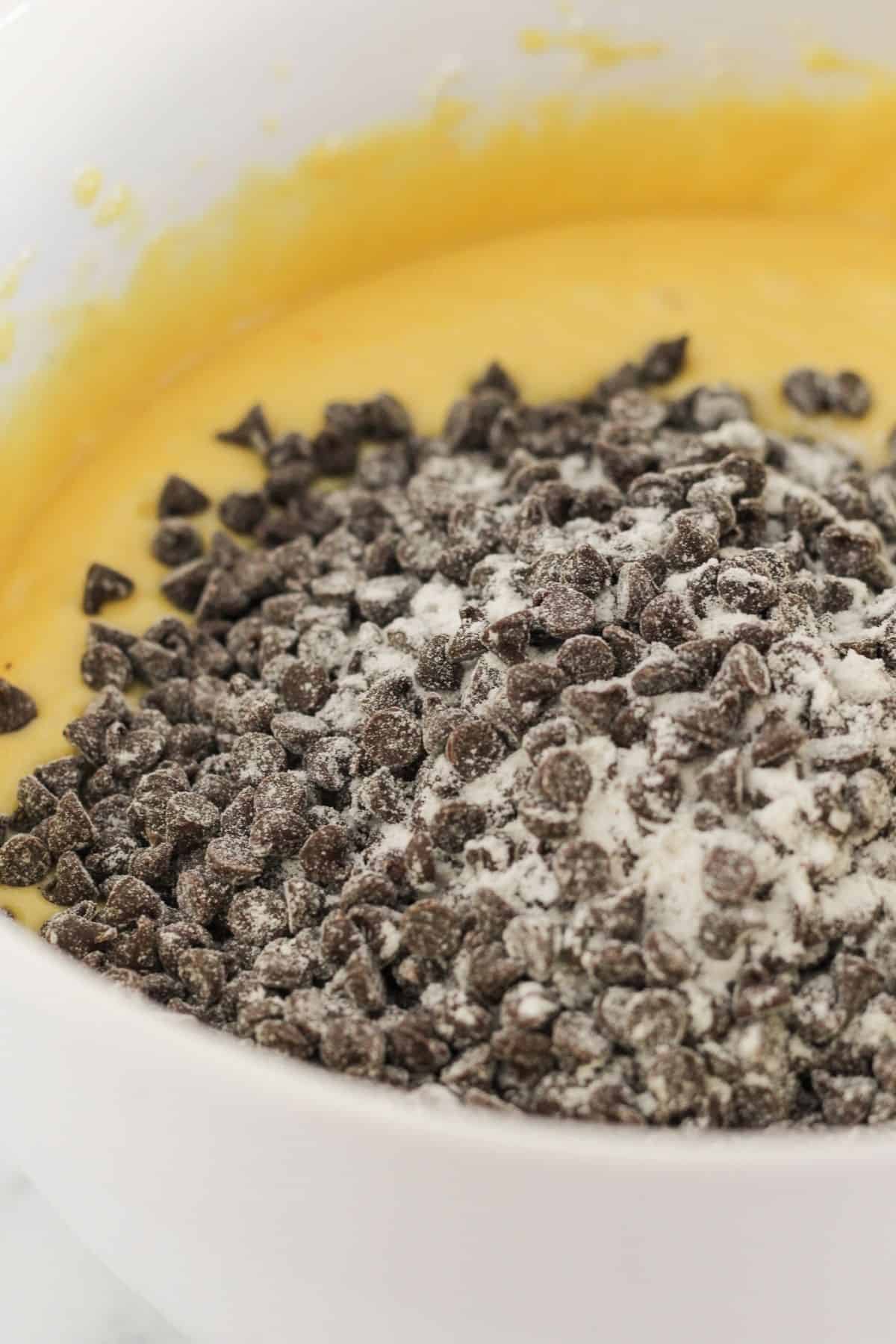 Adding chocolate chips to yellow cake batter.