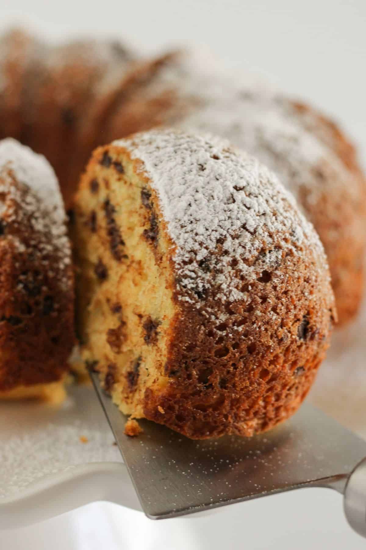 Serving a piece of chocolate chip bundt cake.