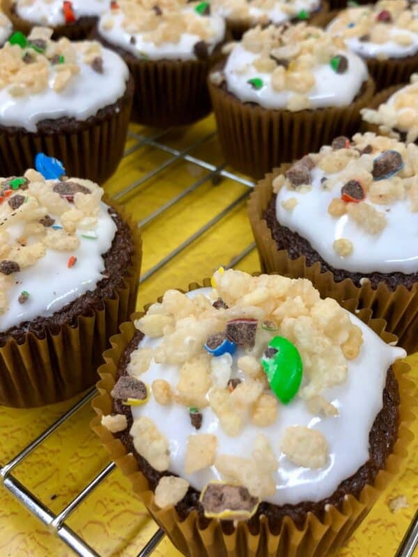 Decorated cupcakes on a cooling rack.