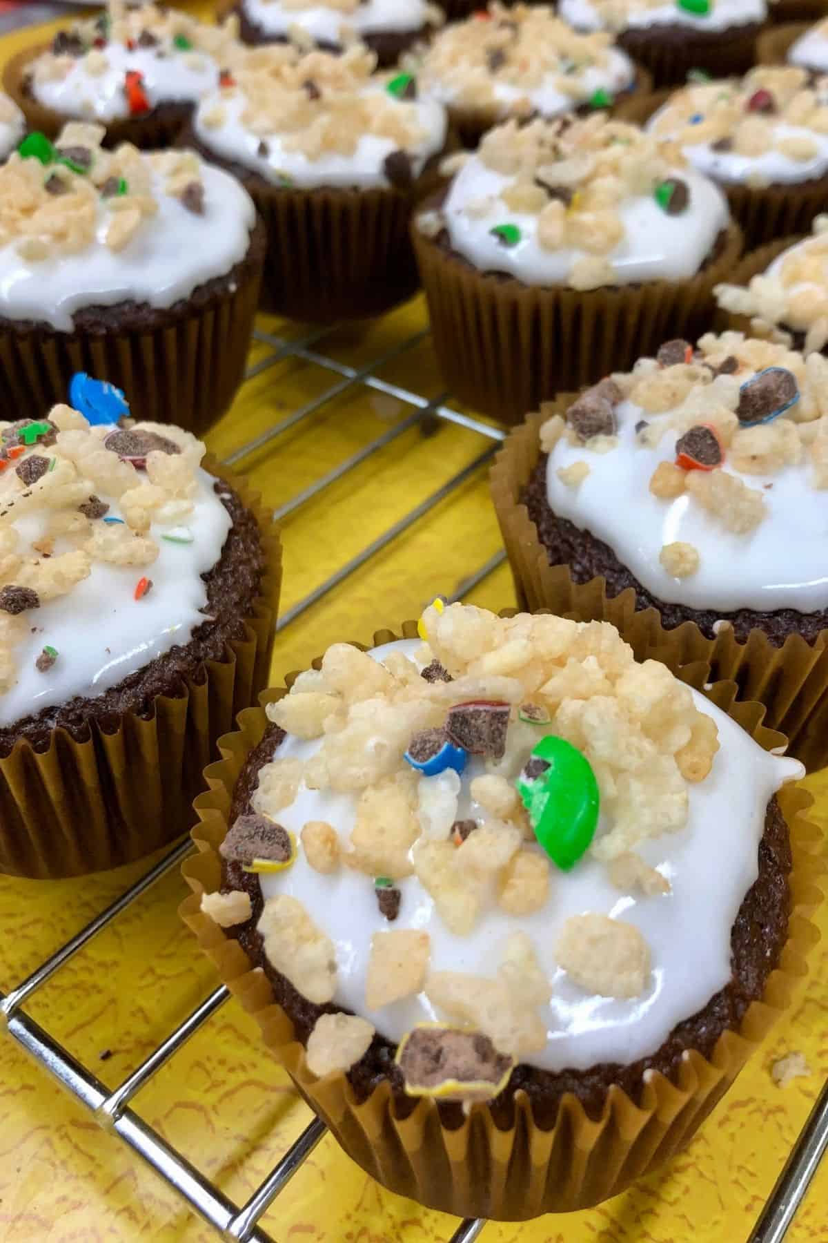 Decorated cupcakes on a cooling rack.