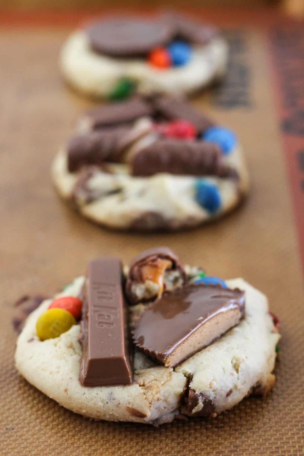 Adding additional candy to the top of Halloween Candy Cookies.